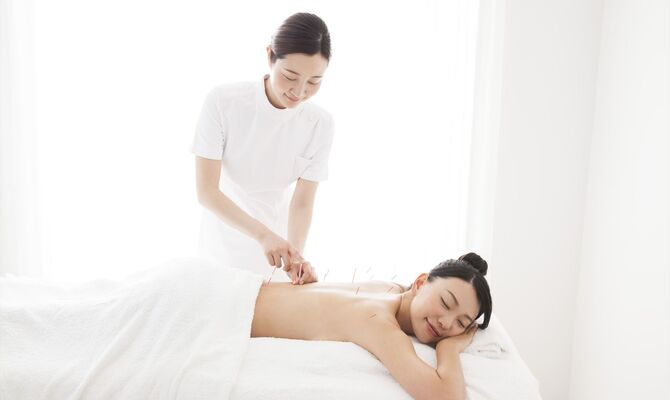 背中に鍼を打つ女性スタッフ